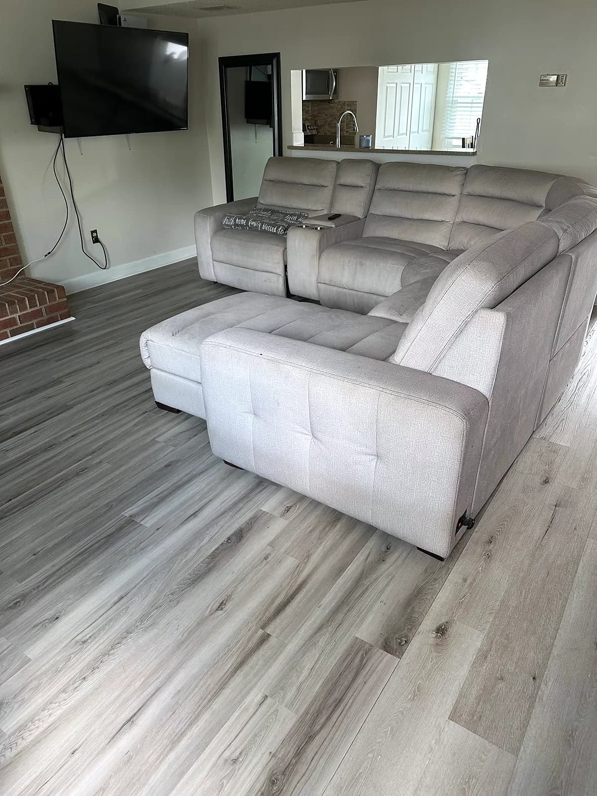 Living room with a light gray sectional sofa and a wall-mounted TV
