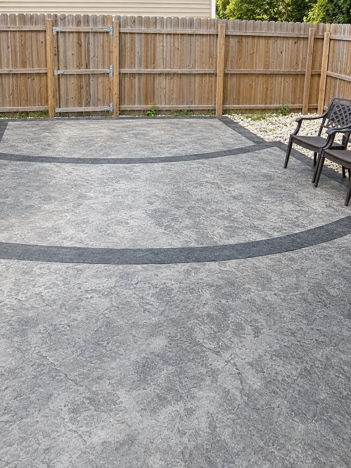 Fenced backyard with a stamped concrete patio and outdoor chairs